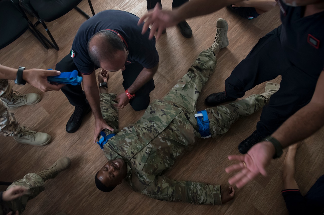 Service members learn how to apply a tourniquet.