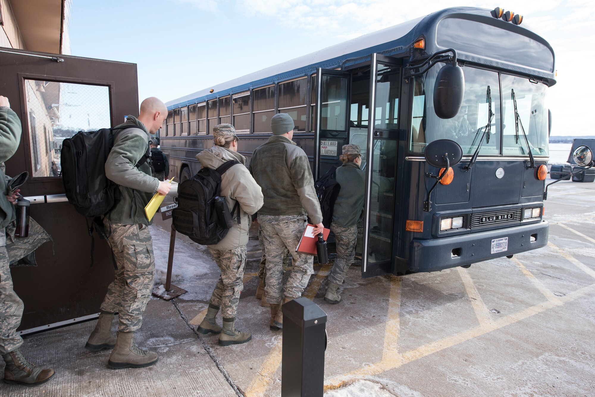 Offutt Airmen board a bus after processing through an exercise deployment line of the Installation Deployment Readiness Cell at Offutt Air Force Base, Nebraska Jan. 29, 2019. The members participated in Phase I of Operational Readiness Exercise Winter Havoc that tested Offutt’s ability to process and deploy a large amount of personnel and equipment on short notice. (U.S. Air Force photo by Delanie Stafford)