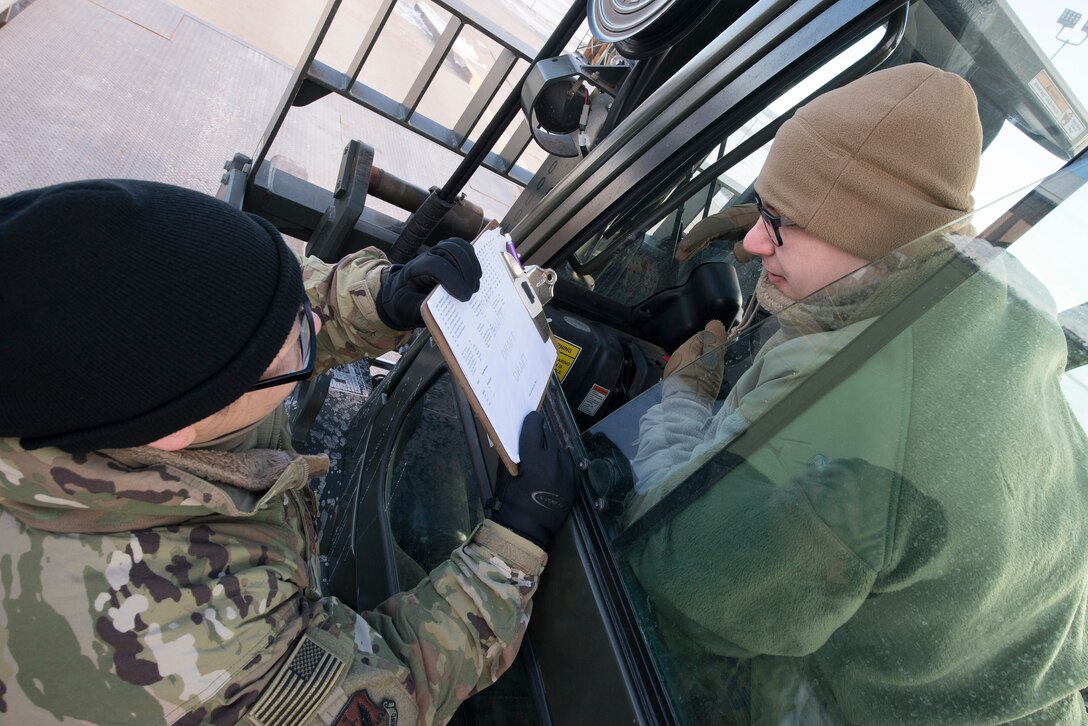 Staff Sgt. Jianna Goto, left, and Senior Airman Dylan Gilbert, 55th Aircraft Maintenance Squadron decentralized material support specialists, weigh cargo inside the Installation Deployment Readiness Cell yard at Offutt Air Force Base, Nebraska Jan. 29, 2019, as part of a deployment exercise. The members participated in Phase I of Operational Readiness Exercise Winter Havoc that tested Offutt’s ability to process and deploy large amounts of personnel and equipment on short notice. (U.S. Air Force photo by Delanie Stafford)