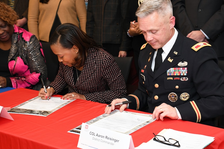 Kari Steele (left), president of the board of commissioners for the Metropolitan Water Reclamation District of Greater Chicago, and Col. Aaron Reisinger (right), commander and district engineer of the U.S. Army Corps of Engineers Chicago District, sign a ceremonial copy of the project partnership agreement between the Corps and MWRD Jan. 31. The MWRD received $33.8 million in federal funds under authority of Section 1043 of the Water Resources Reform and Development Act of 2014, which allows federal funds to transfer through the U.S. Army Corps of Engineers to local sponsors for authorized projects. (U.S. Army photo by Patrick Bray/Released)