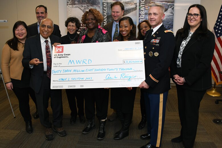 The board of commissioners for the Metropolitan Water Reclamation District of Greater Chicago, hold a novelty check for $33.8 million with Col. Aaron Reisinger (front row, right), commander and district engineer of the U.S. Army Corps of Engineers Chicago District, following a signing ceremony Jan. 3. The MWRD received $33.8 million in federal funds under authority of Section 1043 of the Water Resources Reform and Development Act of 2014, which allows federal funds to transfer through the U.S. Army Corps of Engineers to local sponsors for authorized projects. (U.S. Army photo by Patrick Bray/Released)