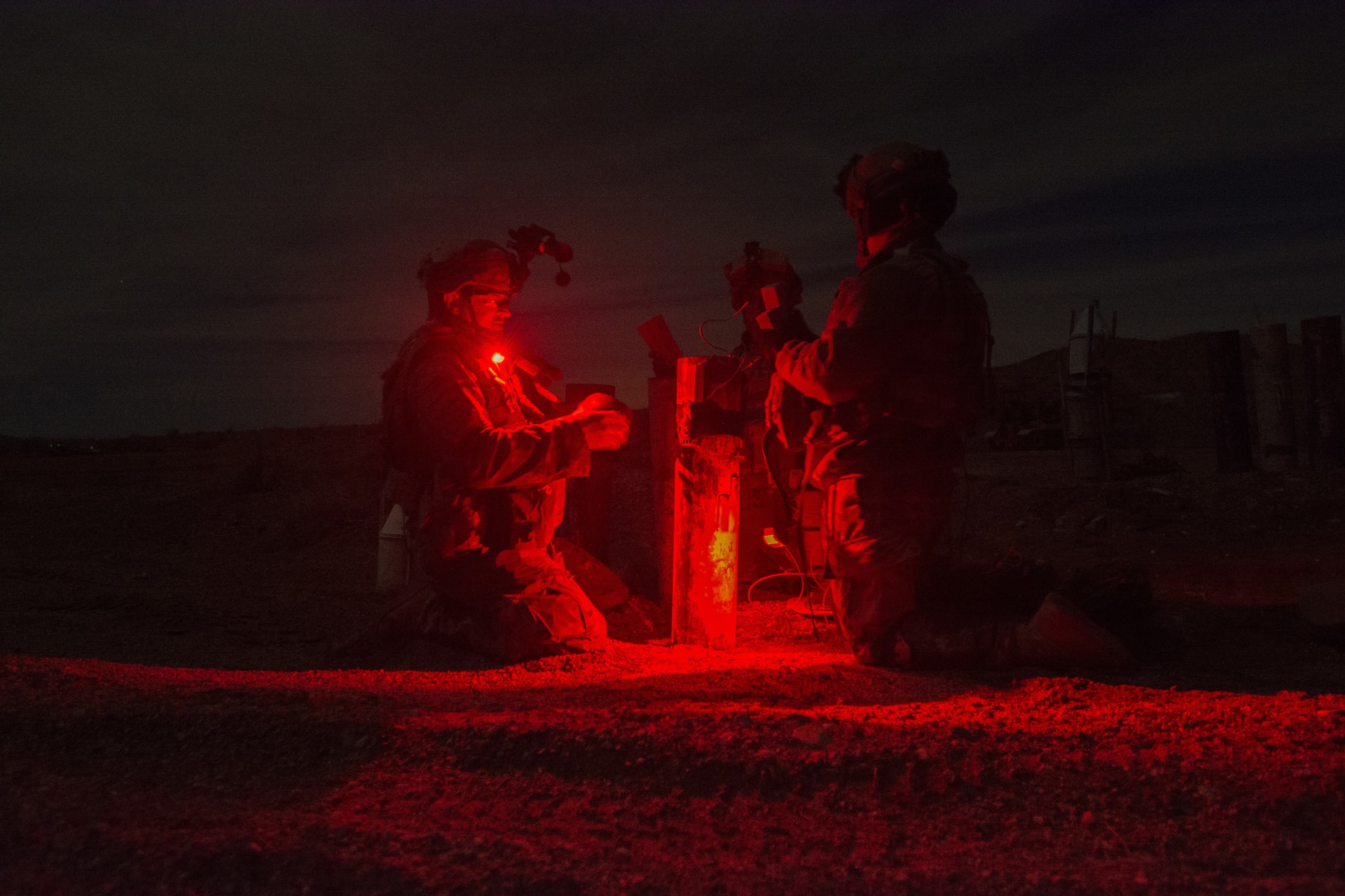 Three Soldiers from the 391st MAC prep an inert crater charge for deployment.