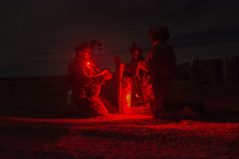 Three Soldiers from the 391st MAC prep an inert crater charge for deployment.