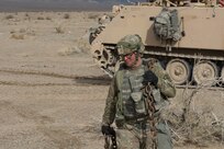 A Soldier from the 391st MAC drags a chain to a disabled vehicle for recovery operations.