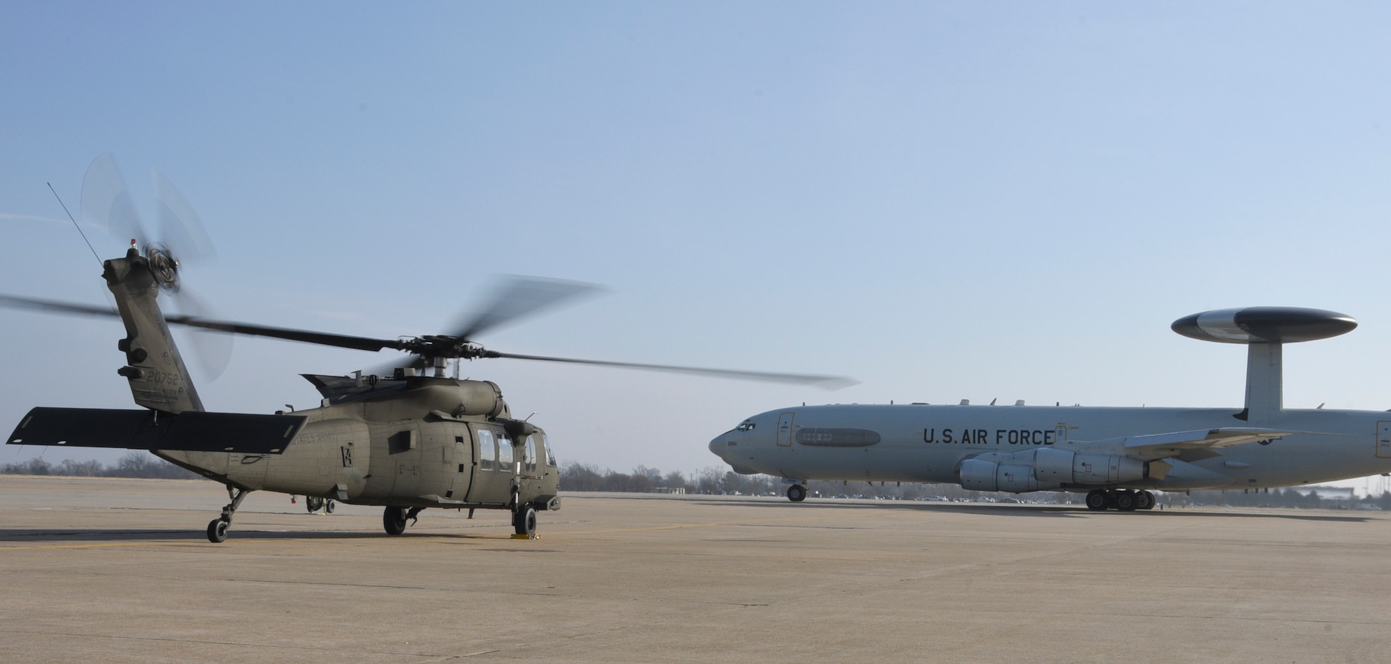 An Oklahoma Army National Guard UH-60M Black Hawk helicopter with rotors turning awaits the take-off of an Air Force E-3 Sentry during a SENTRY REX 19-01 exercise period Jan. 15, Tinker Air Force Base.