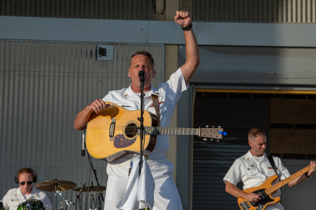 Navy guitarist pumps his fist in the air.