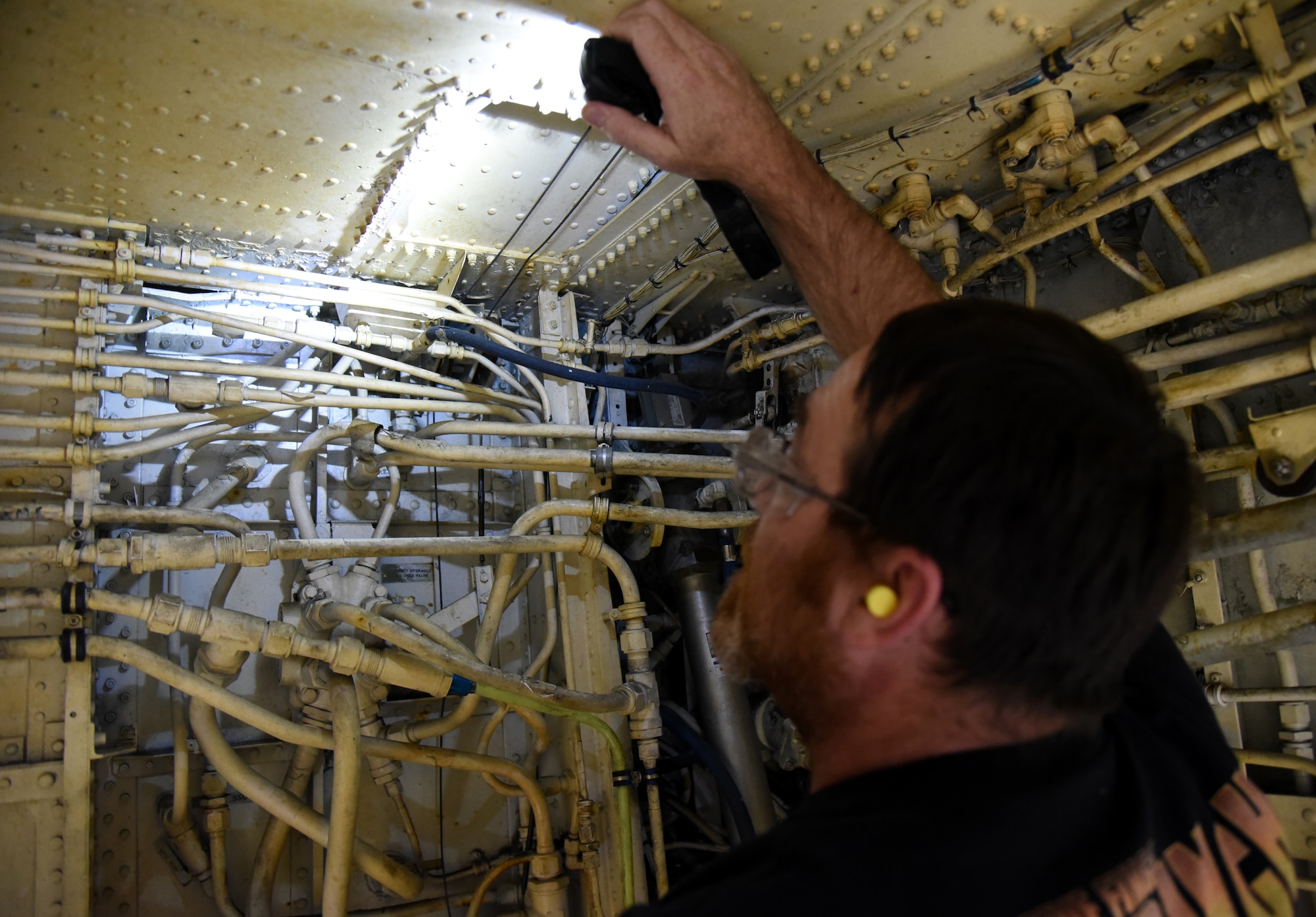 David Matthis, sheet metal mechanic with the 564th Aircraft Maintenance Squadron, shines a light on the area of the keel beam that was corroded on KC-135 Stratotankers. With an all-hands on deck approach, several groups within the Oklahoma City Air Logistics Complex were able to work together to find a solution and fix the important part quicker than expected.