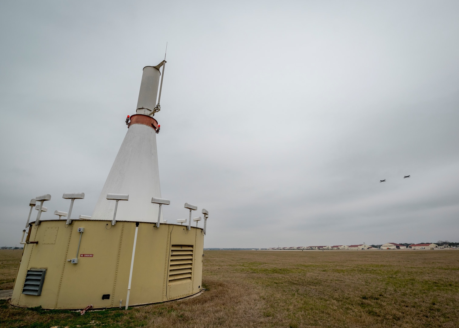 The VORTAC is a combination between antennas for Very High Frequency Omni-Directional Range, VOR, and Tactical Air Navigation, TACAN. Both systems allow for precise navigation from any compass direction within 100-200 nautical miles to directly over the beacon on the west side of the airfield.