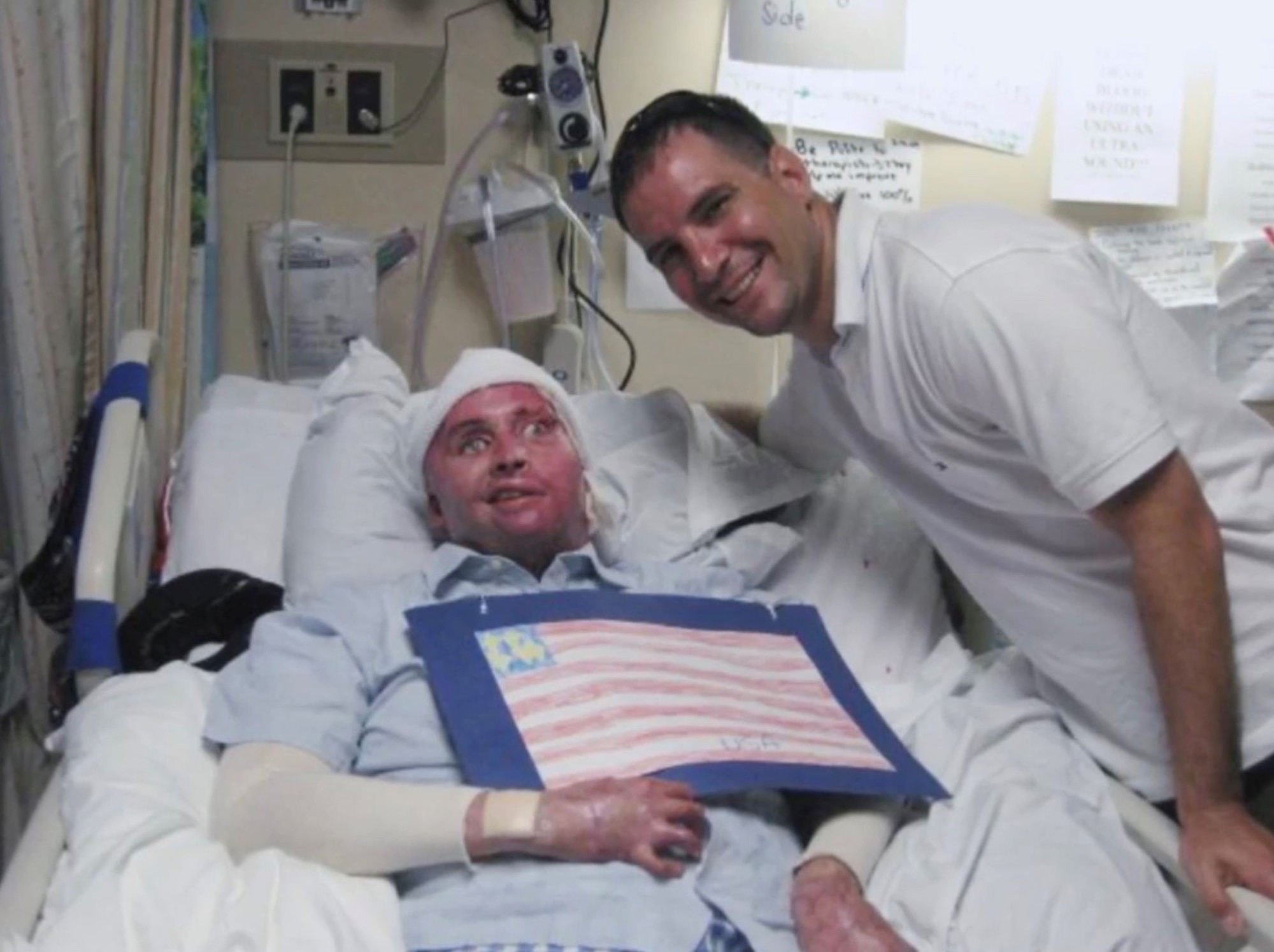 Air Force Lt. Col. Kevin Lombardo, 341st Missile Security Forces Squadron commander, right, visits with Army Spc. Joel Tavera in the hospital.