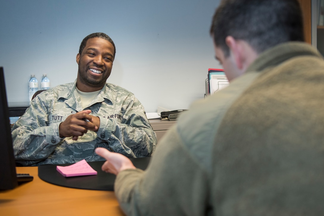 Master Sgt. Hakim Tutt, 514th Air Mobility Wing in-service recruiter, speaks with an active-duty airman about the benefits of the Air Force Reserve