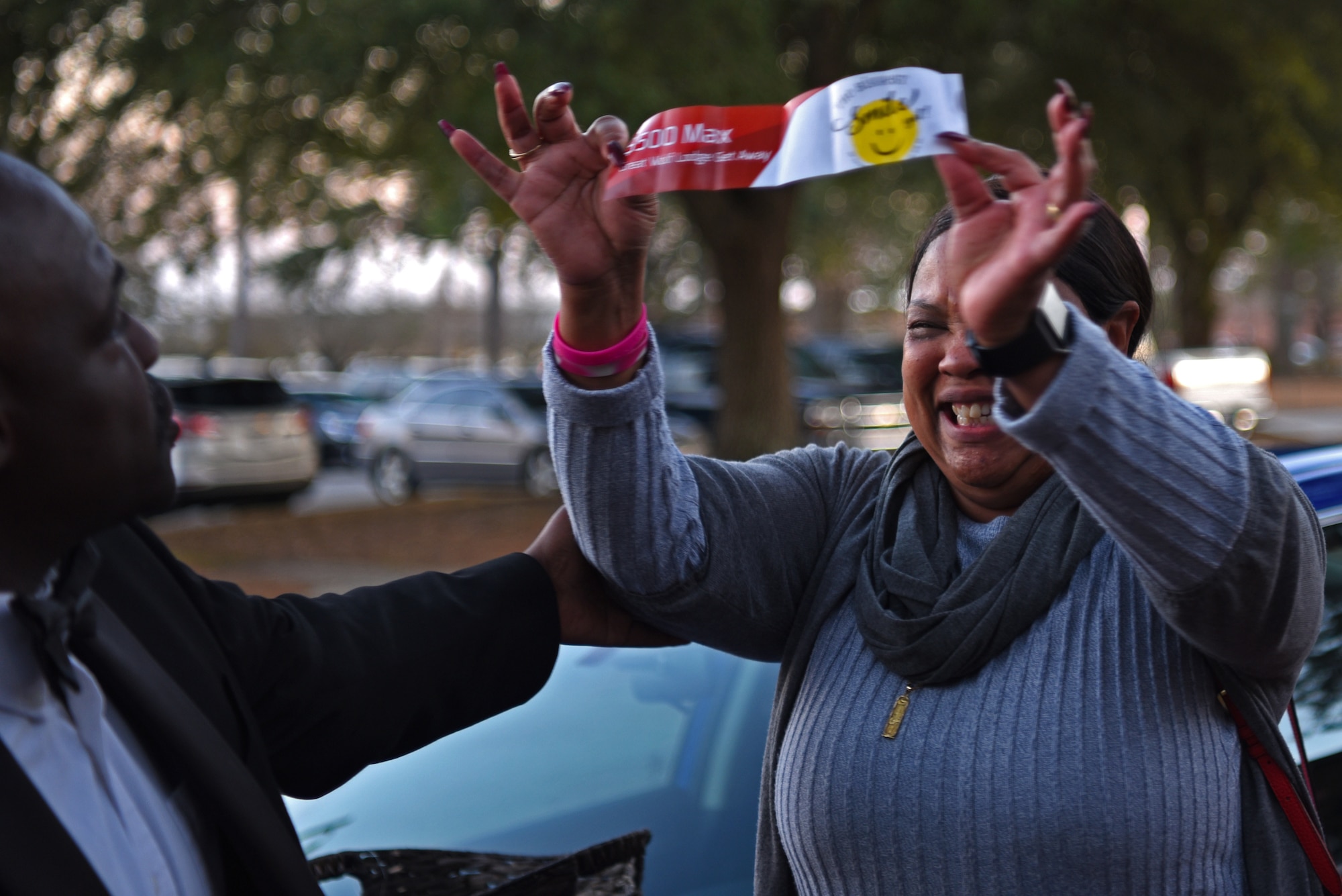Derrick Rhems, 20th Force Support Squadron marketing and promotions director, left, congratulates a Team Shaw member on her alternate prize during a Smile Campaign car giveaway wrap-up party at Shaw Air Force Base, S.C., Jan. 31, 2019.