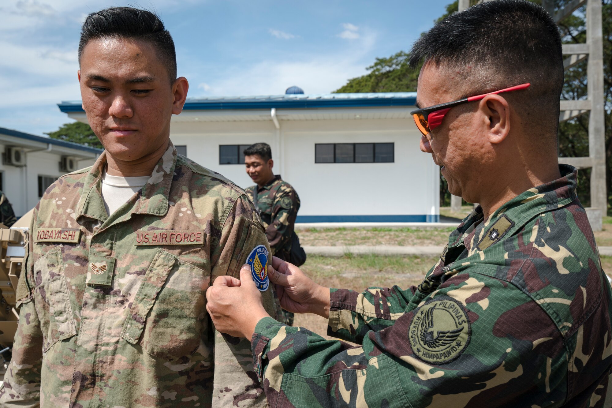 Philippine Air Force Maj. Eric Pua, deputy group commander, 950th Communication Electronic Information Systems Group, places a patch onto U.S. Air Force Senior Airman Lawson Kobayashi, 291st Combat Communication Squadron Cyber Transport Systems journeyman, upon completion of a subject matter expert exchange during Bilateral Air Contingent Exchange-Philippines (BACE-P) at Cesar Basa Air Base, Philippines, January 30, 2019.