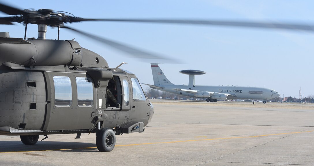 An E-3 Sentry of the 552nd Air Control Wing lines-up on the main runway while an Oklahoma Army National Guard UH-60M Blackhawk of the 1-244th Aviation Regiment prepares to take-off for a SENTRY REX 19-01 mission Jan. 15, 2019, Tinker Air Force Base, Oklahoma. SENTRY REX 19-01 was a multi-service exercise run out of Tinker AFB from Jan. 14-18 focusing on combined force rescue operations of downed aircrew. (U.S. Air Force photo/Greg L. Davis)