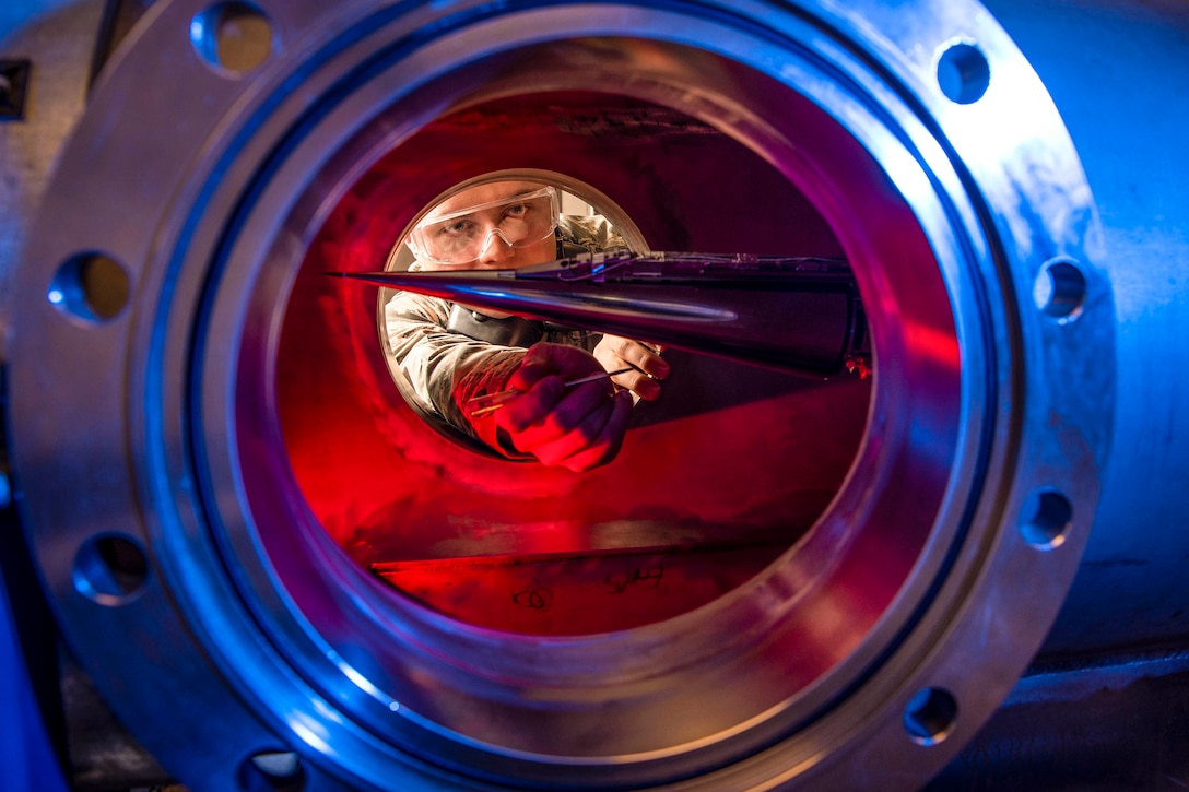 An Air Force cadet looks through a tube.