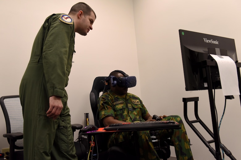 Maj. James Stillwagon, 37th Flying Training Squadron instructor pilot, shows Squadron Leader Adedamola Onalaja, Nigerian Air Force, how their virtual reality training works Jan. 23, 2019, on Columbus Air Force Base, Mississippi. The Nigerian Air Force members visited Columbus AFB to check on one of their students and to see the different aspects of pilot training. (U.S. Air Force photo by Senior Airman Beaux Hebert)