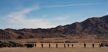 Airman walk the flight line looking for foreign object debris.