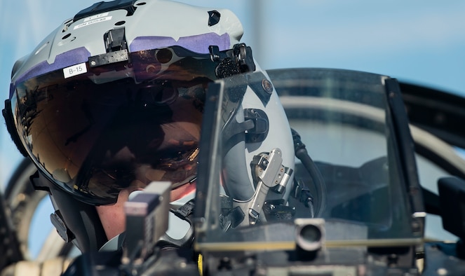 An Airman sits in the cockpit of an F-16 Fighting Falcon fighter jet.