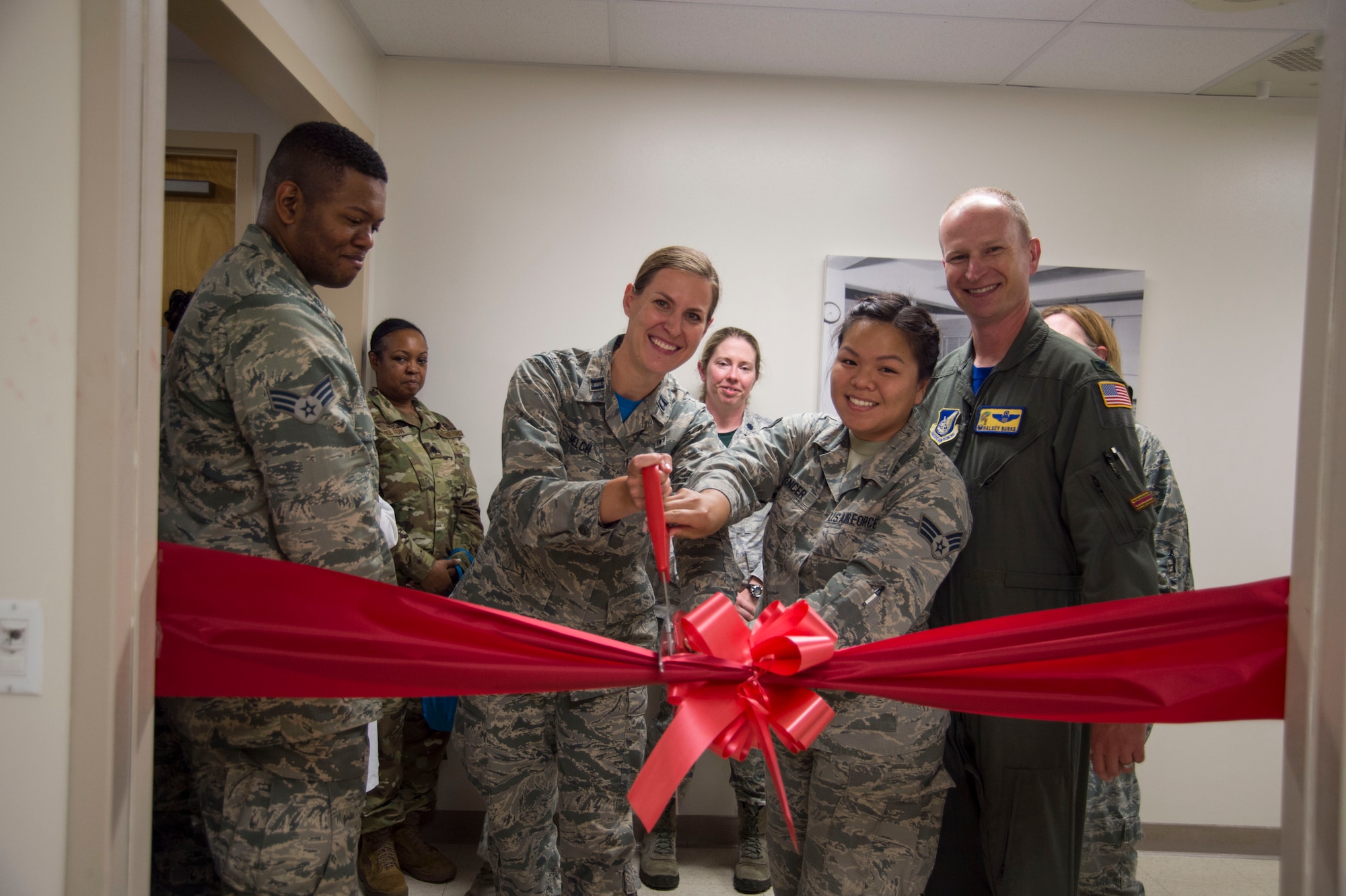 Capt. Christine Melch, 15th Aerospace Medicine Squadron advanced general dentist, and Senior Airman Maryan Spencer, 15th Medical Support Squadron, logistics specialist, cut a ribbon to commemorate the opening of the new lactation room at the Hickam Clinic, Joint Base Pearl Harbor-Hickam, Hawaii, Feb. 1, 2019. The lactation room gives Airmen and their families a safe and inviting location to pump or feed their children. (U.S. Air Force photo by Tech. Sgt. Heather Redman)