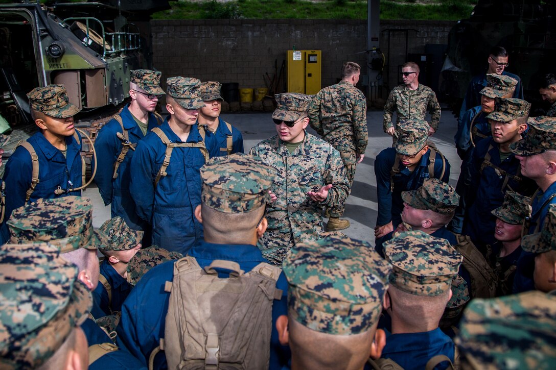 U.S. Marine Corps Sgt. Kevin Storman, (center) platform instructor, Assault Amphibian School (AAS) Battalion, Training Command, calls his students into a school circle at Marine Corps Base Camp Pendleton, California, Jan. 28, 2019. The students were being evaluated on ground guidance procedures and techniques when guiding an AAV.(U.S. Marine Corps photo by Cpl. Juan Bustos)