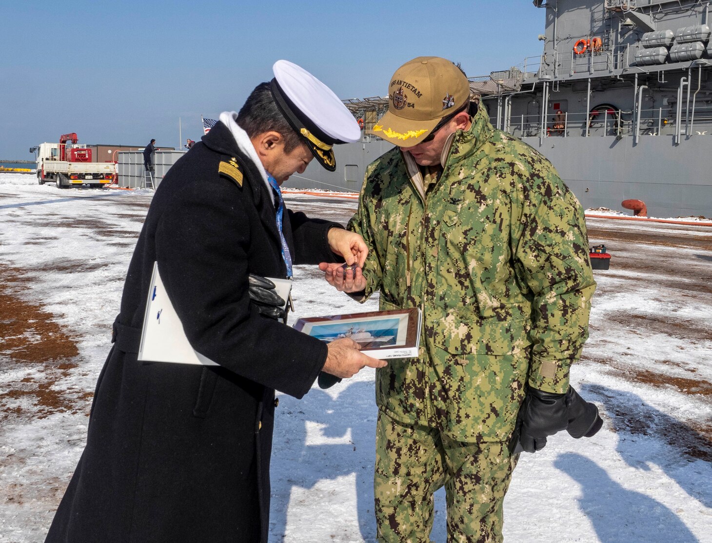 190203-N-CP113-002 ISHIKARI, Japan (Feb. 03, 2019) Capt. George Kessler, Jr., from Albany, Missouri, is greeted by Capt. Takuya Suzuki of the Japanese Maritime Self Defense Force Yoichi Coastal Defense Group, after Ticonderoga-class guided-missile cruiser USS Antietam (CG 54) pulled into Ishikari to attend the 70th Annual Sapporo Snow Festival. This is the 36th year the U.S. Navy has participated in the festival, allowing Sailors a unique opportunity to experience Japanese culture and tradition while strengthening the close friendship between the U.S. Navy and the citizens of Japan. (U.S. Navy photo by Lt. Marissa Liu/Released)