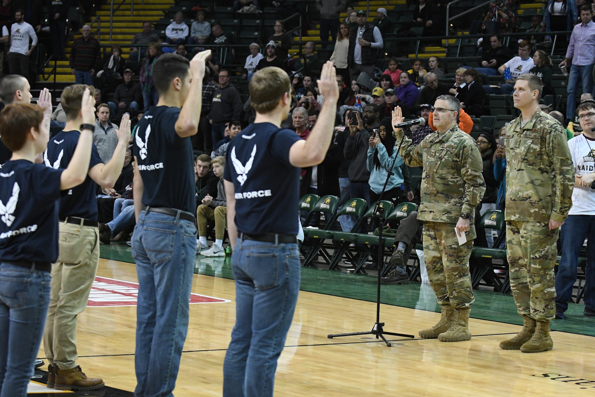 Maj. Gen. William Cooley, Air Force Research Laboratory commander, administers the oath of enlistment to 25 future Airmen at a Wright State University basketball game Jan. 26, 2018 athe the Erwin J. Nutter Center. (Courtesy photo).