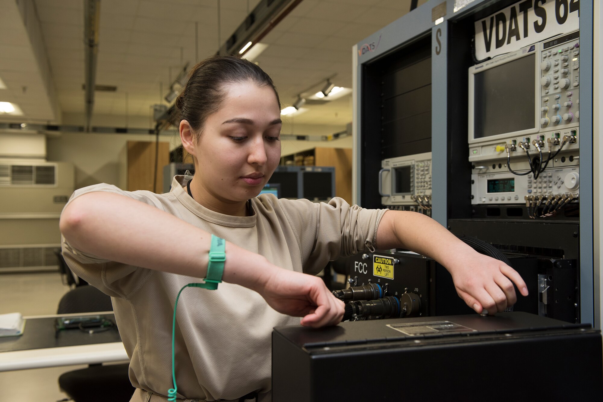 Airman 1st Class Vera Schwenk, an avionics technician assigned to the 509th Maintenance Squadron, removes a panel from a part of the Versatile Diagnostics Automatic Test Station.