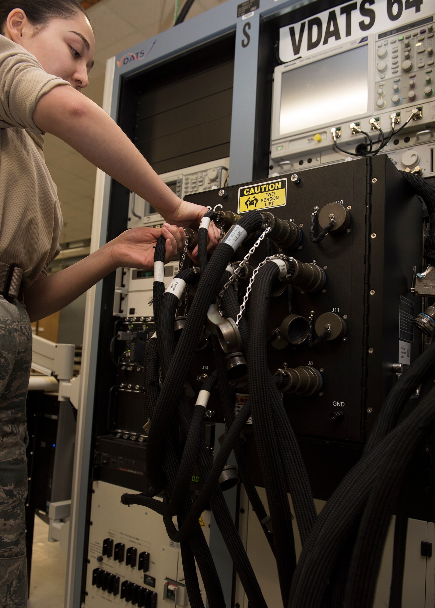 Airman 1st Class Vera Schwenk, an avionics technician assigned to the 509th Maintenance Squadron, adjusts electrical cables of the Versatile Diagnostics Automatic Test Station.