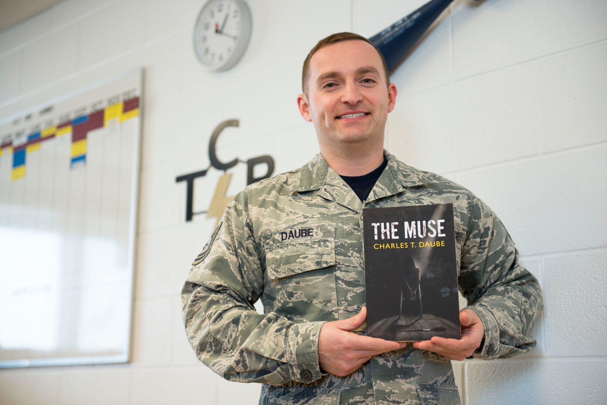 Tech. Sgt. Charlie Daube, a munitions inspector for the 167th Maintenance Squadron, holds a copy of his recently published novel, “The Muse.” (U.S. Air National Guard photo by Senior Airman Teddy Michon)