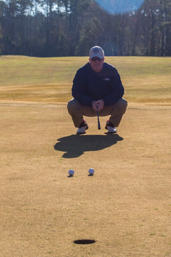 Marine Corps Air Station Cherry Point sergerant major, Sgt. Maj. Paul McElearney visualizes his upcoming putt during the Headquarters and Headquarters Squadron (H&HS) Polar Bear Superball Tournament at MCAS Cherry Point, North Carolina, Jan. 25, 2019. The golf tournament was held to raise donations for the squadrons’ 2019 Marine Corps Birthday Ball. Each team consisted of four golfers, with prizes being awarded to the first, second and third place teams. The first place team won a $35 gift card per golfer to use at the Sound of Freedom Golf Course shop at MCAS Cherry Point and the second place team won a free round of golf at the course per golfer. (U.S. Marine Corps photo by Lance Cpl. Andrew King)