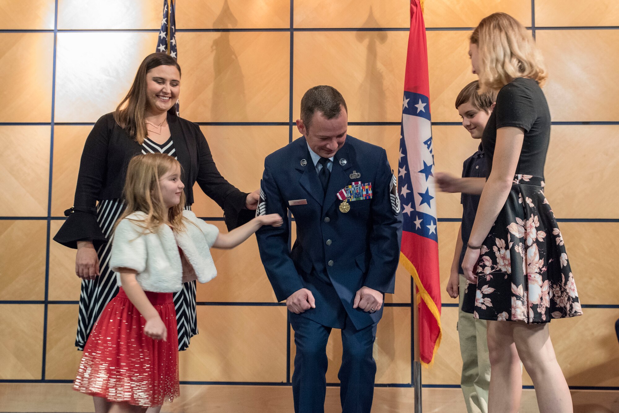 Chief Master Sgt. Jeremiah J. Brewer, superintendent of the 188th Force Support Squadron, gets his stripes pinned on by his wife and children at Ebbing Air National Guard Base, Fort Smith, Ark., Nov. 4, 2018. Brewer came to the 188th from the 189th FSS where he worked as manpower and personnel superintendent. (U.S. Air National Guard photo by Staff Sgt. Matthew Matlock)
