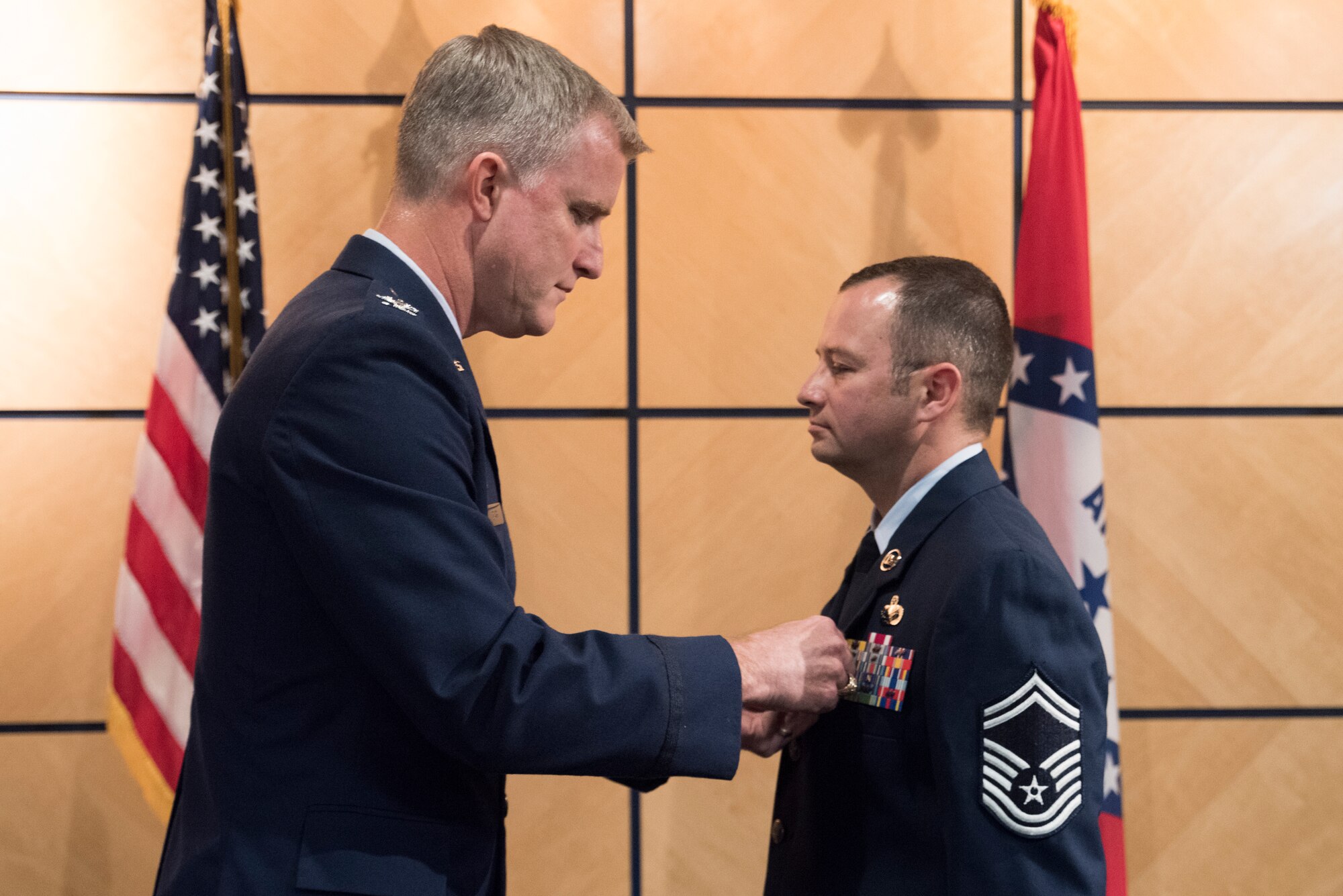 Col. Donald L. Clark, commander of the 189th Mission Support Group, presents Chief Master Sgt. Jeremiah J. Brewer with the Meritorious Service Medal during his promotion ceremony at Ebbing Air National Guard Base, Fort Smith, Ark., Nov. 4, 2018. The Meritorious Service Medal is awarded for exemplary service in a noncombatant role. (U.S. Air National Guard photo by Tech. Sgt. Daniel Condit)