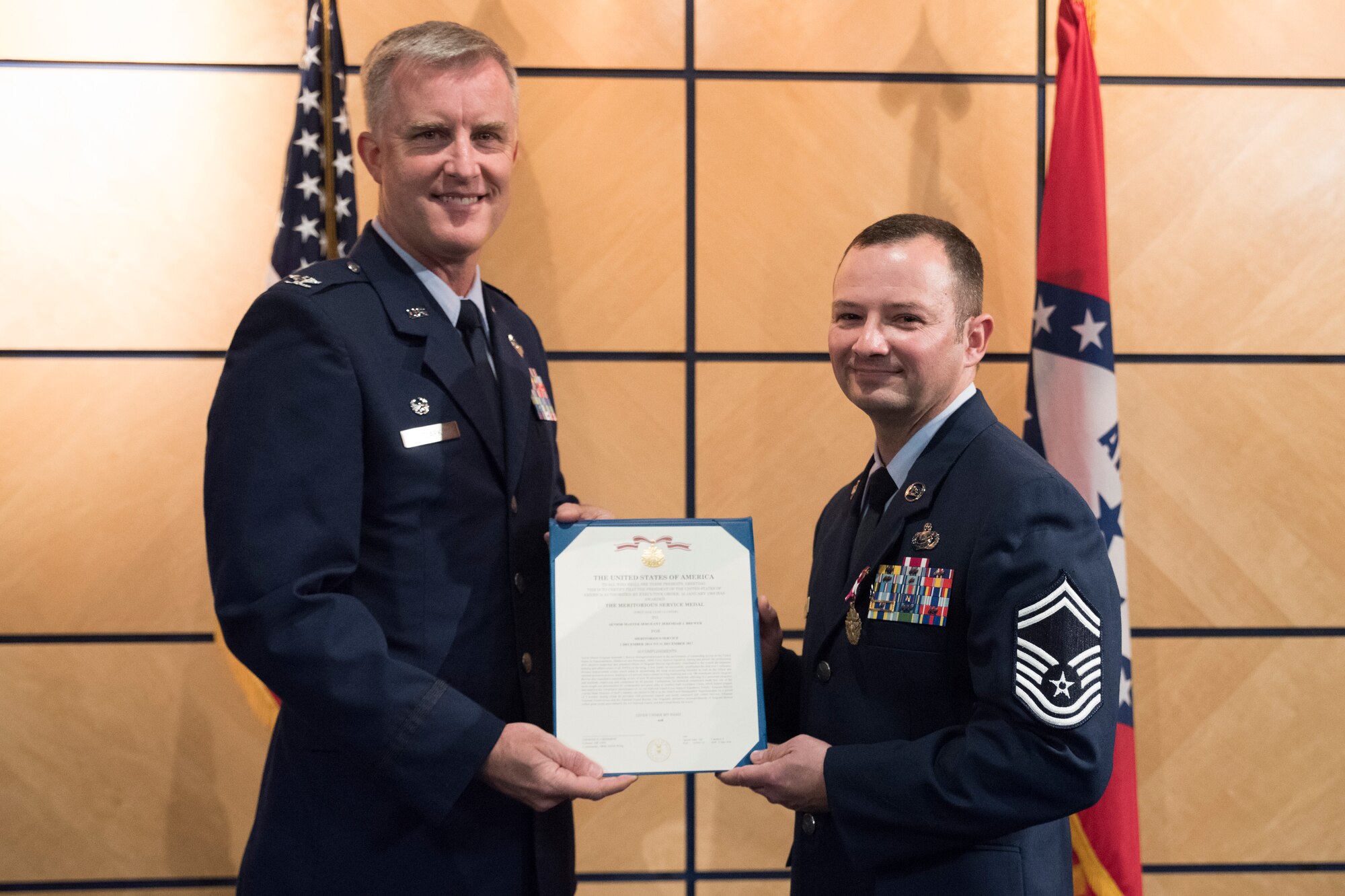 Col. Donald L. Clark, commander of the 189th Mission Support Group, presents Chief Master Sgt. Jeremiah J. Brewer with the Meritorious Service Medal during his promotion ceremony at Ebbing Air National Guard Base, Fort Smith, Ark., Nov. 4, 2018. The Meritorious Service Medal is awarded for exemplary service in a noncombatant role.