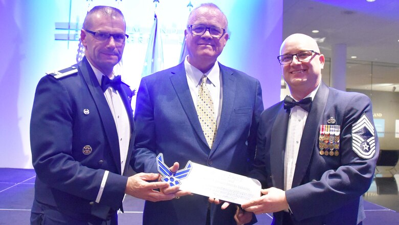 Col. Phil Heseltine, 931st Air Refueling Wing commander, and Chief Master Sgt. Seth Thomas, 931 ARW acting command chief, present Ed Hearn with a gift to show their appreciation for speaking at the 2019 Annual Awards Banquet at the Wichita Art Museum, Feb. 2, 2019.  Hearn, an author and former member of the New York Mets, was the guest speaker for the annual event.