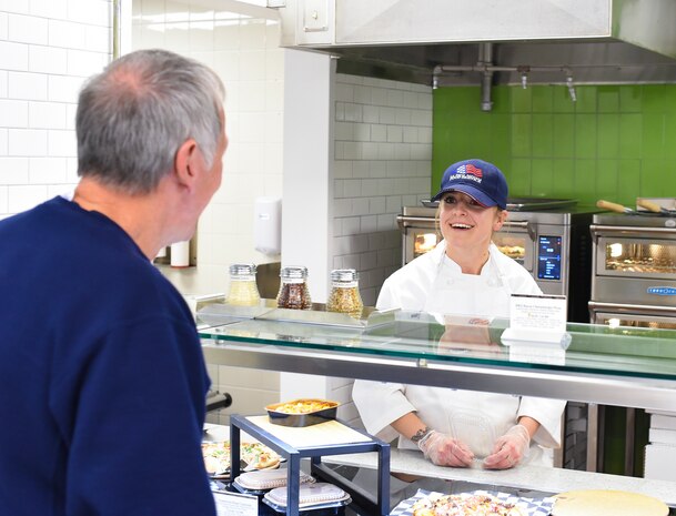 Airman 1st Class Britton Black, 628th Force Support Squadron food services specialist, greets a customer after the renovated Gaylor Dining Facility officially reopened Feb. 1, 2019, at Joint Base Charleston, S.C.