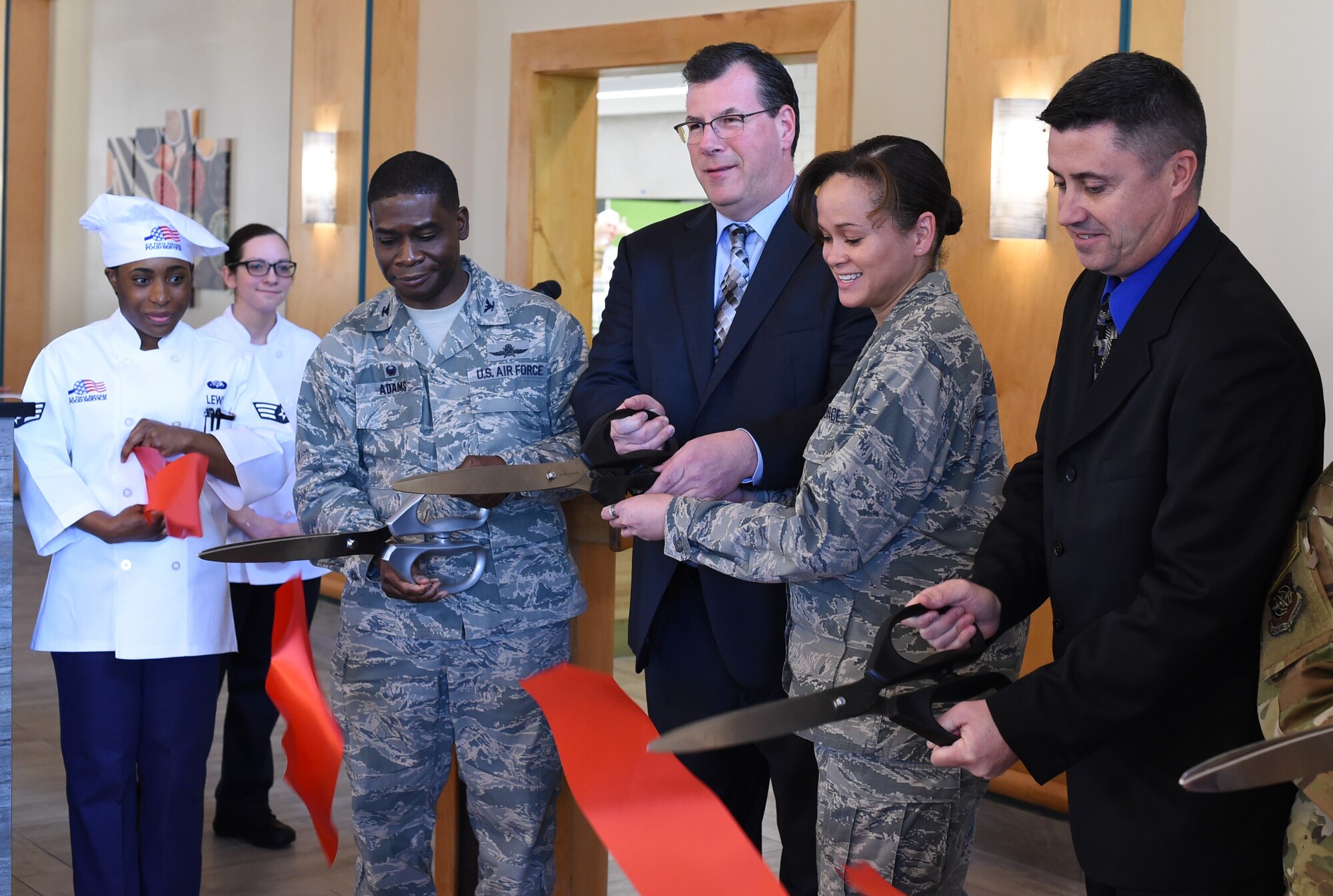Colonel Terrence Adams, left, 628th Air Base Wing commander, joins Lt. Col. Jacqueline Sukhlall, second from right, Air Force Services Activity Operations Directorate deputy director, along with civilian contractors to mark the opening of the Gaylor Dining Facility Feb. 1, 2019, at Joint Base Charleston, S.C.