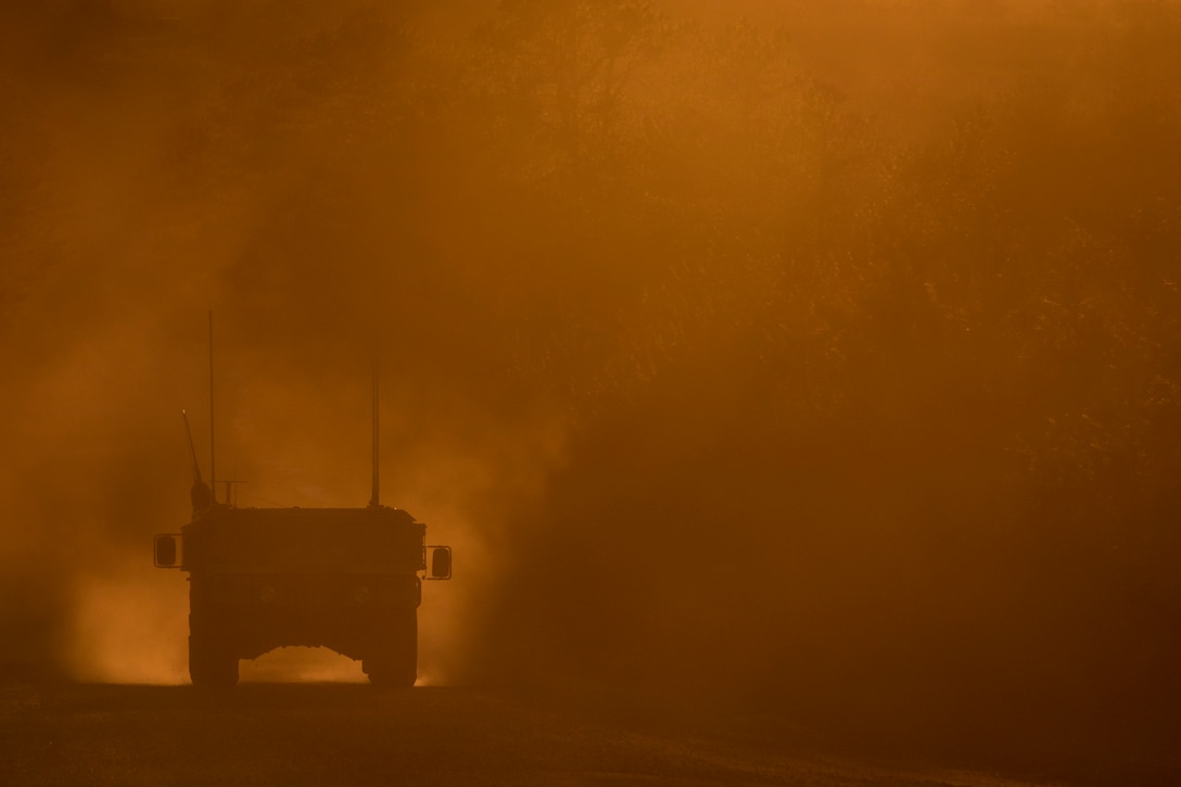 A humvee drives through mist during training.