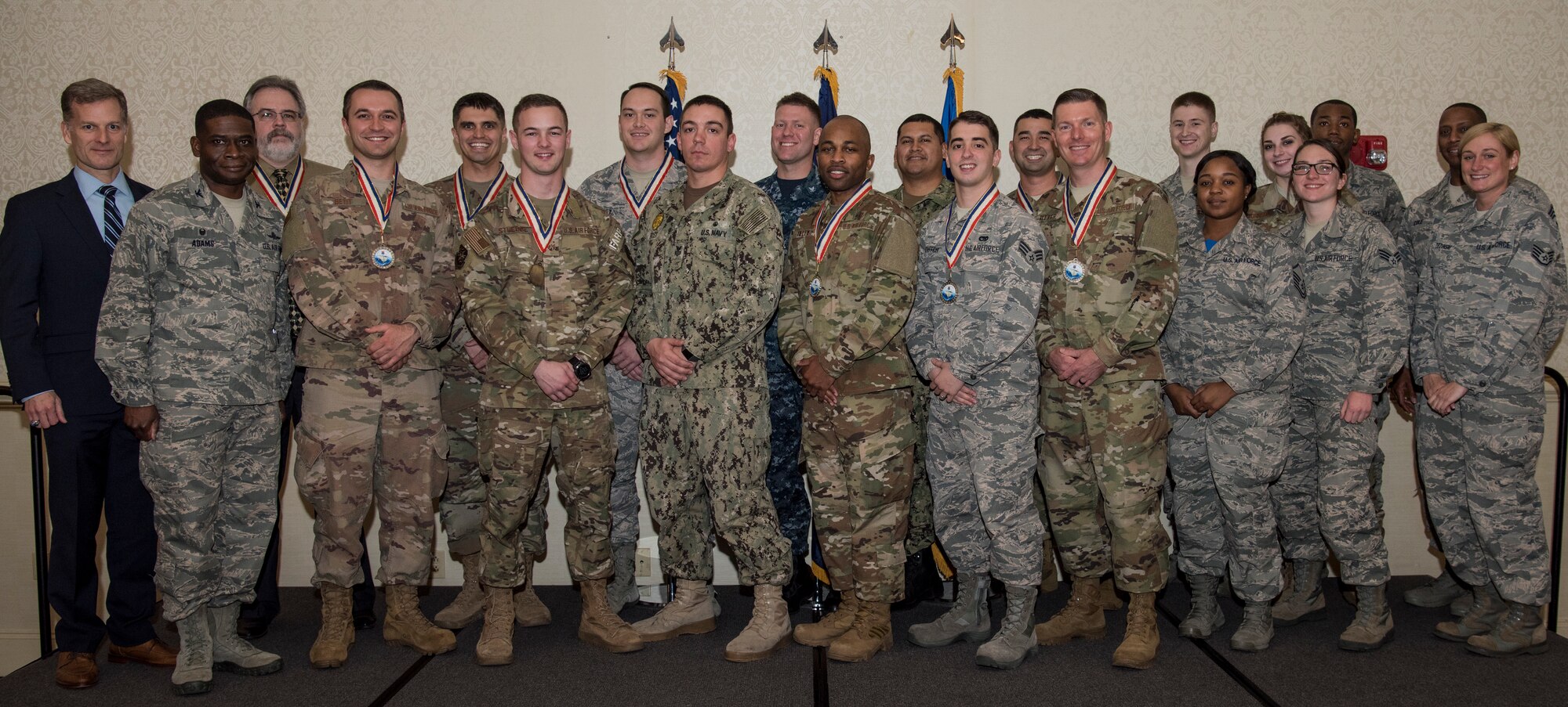 The annual award winners of the 628th Air Base Wing and Naval Support Activity Charleston stand with guest speaker, retired U.S. Air Force Maj. Gen. Dondi Costin, far left, and 628th Air Base Wing leadership during an annual awards ceremony Feb. 1, 2019, at the Charleston Club on Joint Base Charleston, S.C.