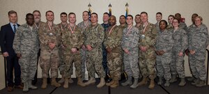 The annual award winners of the 628th Air Base Wing and Naval Support Activity Charleston stand with guest speaker, retired U.S. Air Force Maj. Gen. Dondi Costin, far left, and 628th Air Base Wing leadership during an annual awards ceremony Feb. 1, 2019, at the Charleston Club on Joint Base Charleston, S.C.