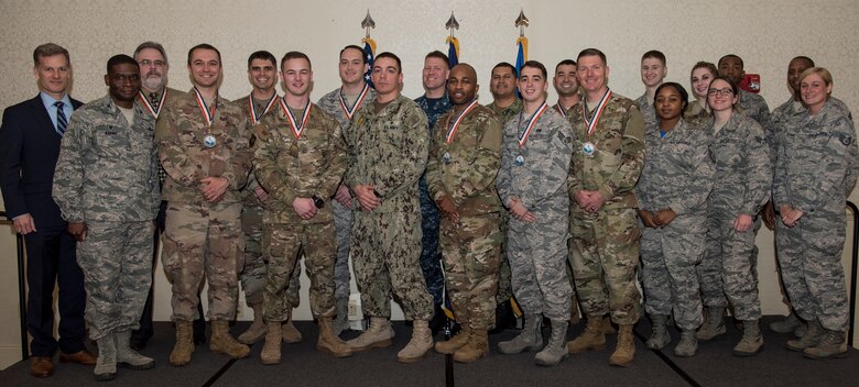 The annual award winners of the 628th Air Base Wing and Naval Support Activity Charleston stand with guest speaker, retired U.S. Air Force Maj. Gen. Dondi Costin, far left, and 628th Air Base Wing leadership during an annual awards ceremony Feb. 1, 2019, at the Charleston Club on Joint Base Charleston, S.C.