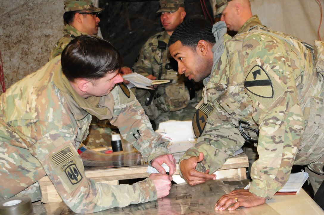 Two soldiers confer over a map