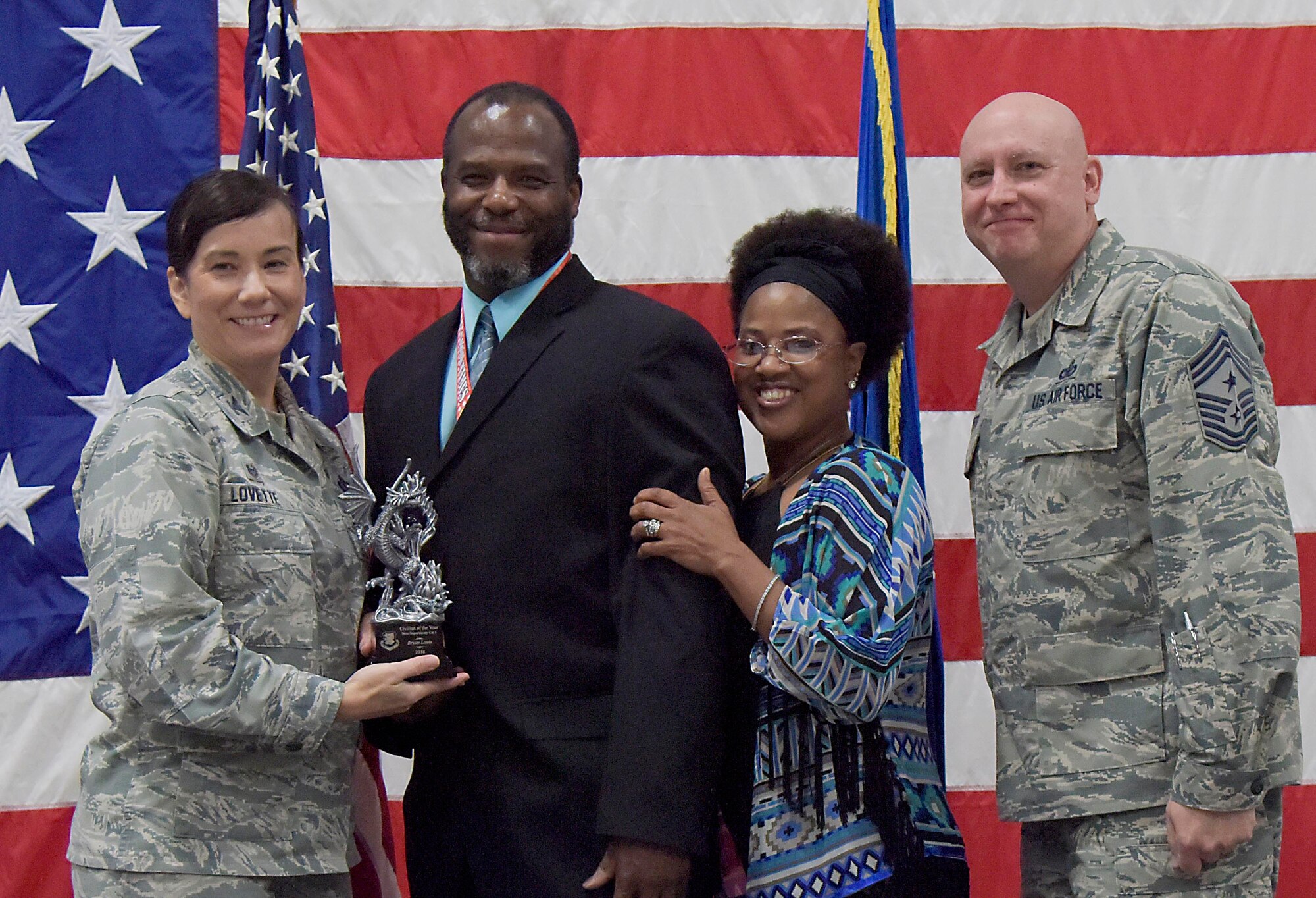 U.S. Air Force Col. Debra Lovette, 81st Training Wing commander, and Chief Master Sgt. David Pizzuto, 81st TRW command chief, present Brian Louis, 81st Comptroller Squadron financial technician, with the Civilian of the Year award, Non-Supervisory Category I, during the 81st Training Wing's 2018 Annual Awards Ceremony inside a hangar at Keesler Air Force Base, Mississippi, Feb. 1, 2019. During the ceremony, base leadership recognized outstanding Airmen and civilians from across the installation for their accomplishments throughout 2018. (U.S. Air Force photo by Kemberly Groue)