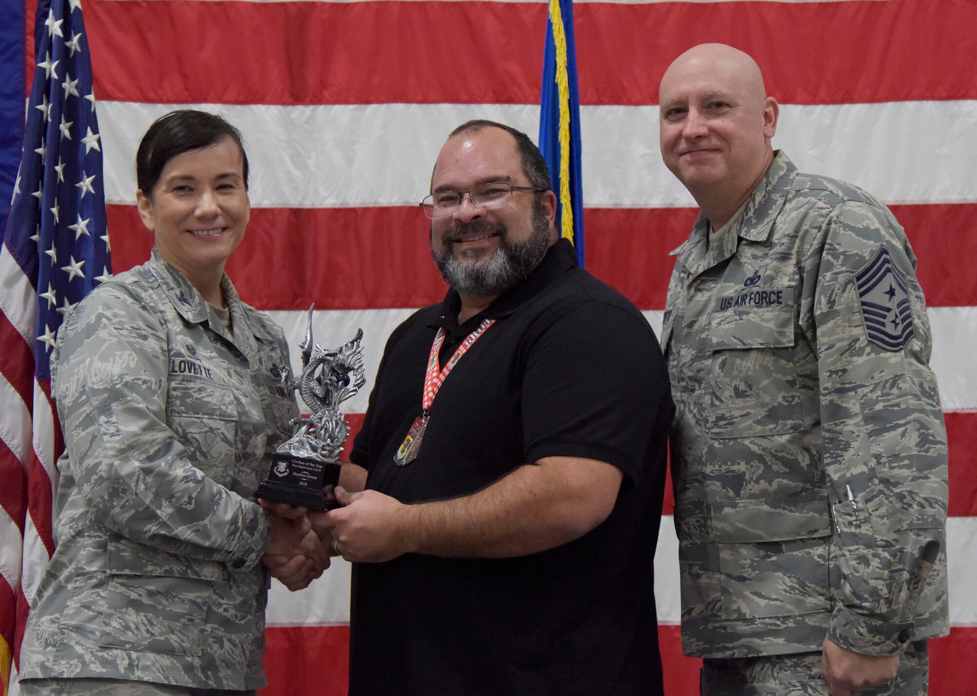 U.S. Air Force Col. Debra Lovette, 81st Training Wing commander, and Chief Master Sgt. David Pizzuto, 81st TRW command chief, present Stephen Dereis, 81st Dental Squadron dental lab technician, with the Civilian of the Year award, Non-Supervisory Category II, during the 81st Training Wing's 2018 Annual Awards Ceremony inside a hangar at Keesler Air Force Base, Mississippi, Feb. 1, 2019. During the ceremony, base leadership recognized outstanding Airmen and civilians from across the installation for their accomplishments throughout 2018. (U.S. Air Force photo by Kemberly Groue)