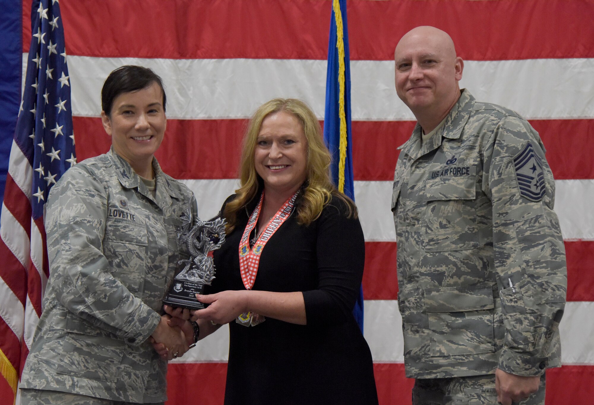 U.S. Air Force Col. Debra Lovette, 81st Training Wing commander, and Chief Master Sgt. David Pizzuto, 81st TRW command chief, present Brandie Saucier, 81st Diagnostic and Therapeutics Squadron transfusion services supervisor, with the Civilian of the Year award, Non-Supervisory Category III, during the 81st Training Wing's 2018 Annual Awards Ceremony inside a hangar at Keesler Air Force Base, Mississippi, Feb. 1, 2019. During the ceremony, base leadership recognized outstanding Airmen and civilians from across the installation for their accomplishments throughout 2018. (U.S. Air Force photo by Kemberly Groue)
