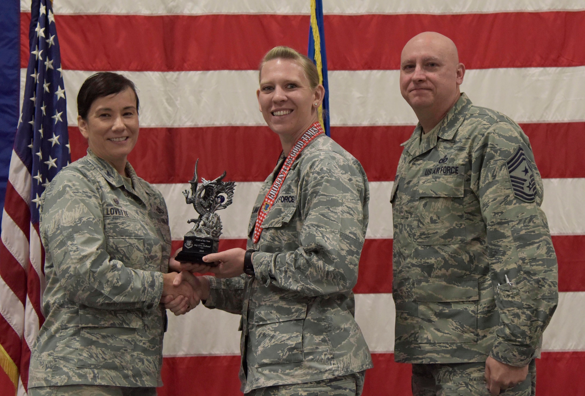 U.S. Air Force Col. Debra Lovette, 81st Training Wing commander, and Chief Master Sgt. David Pizzuto, 81st TRW command chief, present Maj. Erin Holland, 81st Force Support Squadron operations officer, with the Field Grade Officer of the Year award during the 81st Training Wing's 2018 Annual Awards Ceremony inside a hangar at Keesler Air Force Base, Mississippi, Feb. 1, 2019. During the ceremony, base leadership recognized outstanding Airmen and civilians from across the installation for their accomplishments throughout 2018. (U.S. Air Force photo by Kemberly Groue)