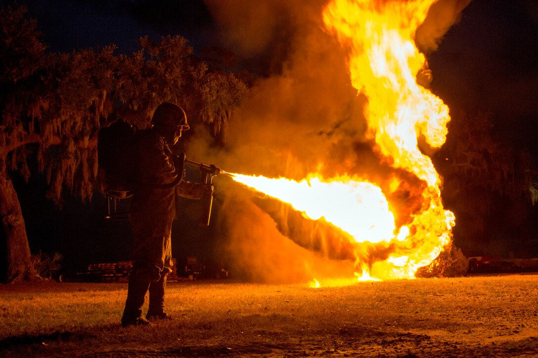 A Marine burns Christmas trees with a flamethrower