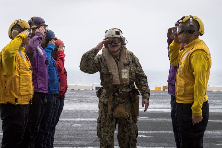 EAST CHINA SEA (Feb. 5, 2019) Commander of U.S. 7th Fleet, Vice Adm. Phil Sawyer, renders a salute through side boys on the flight deck of the amphibious assault ship USS Wasp (LHD 1) during a visit between U.S. and Japan military officials to observe amphibious operations at sea. Wasp, flagship of the Wasp Amphibious Ready Group, with embarked 31st Marine Expeditionary Unit, is operating in the Indo-Pacific region to enhance interoperability with partners and serve as a ready-response force for any type of contingency.
