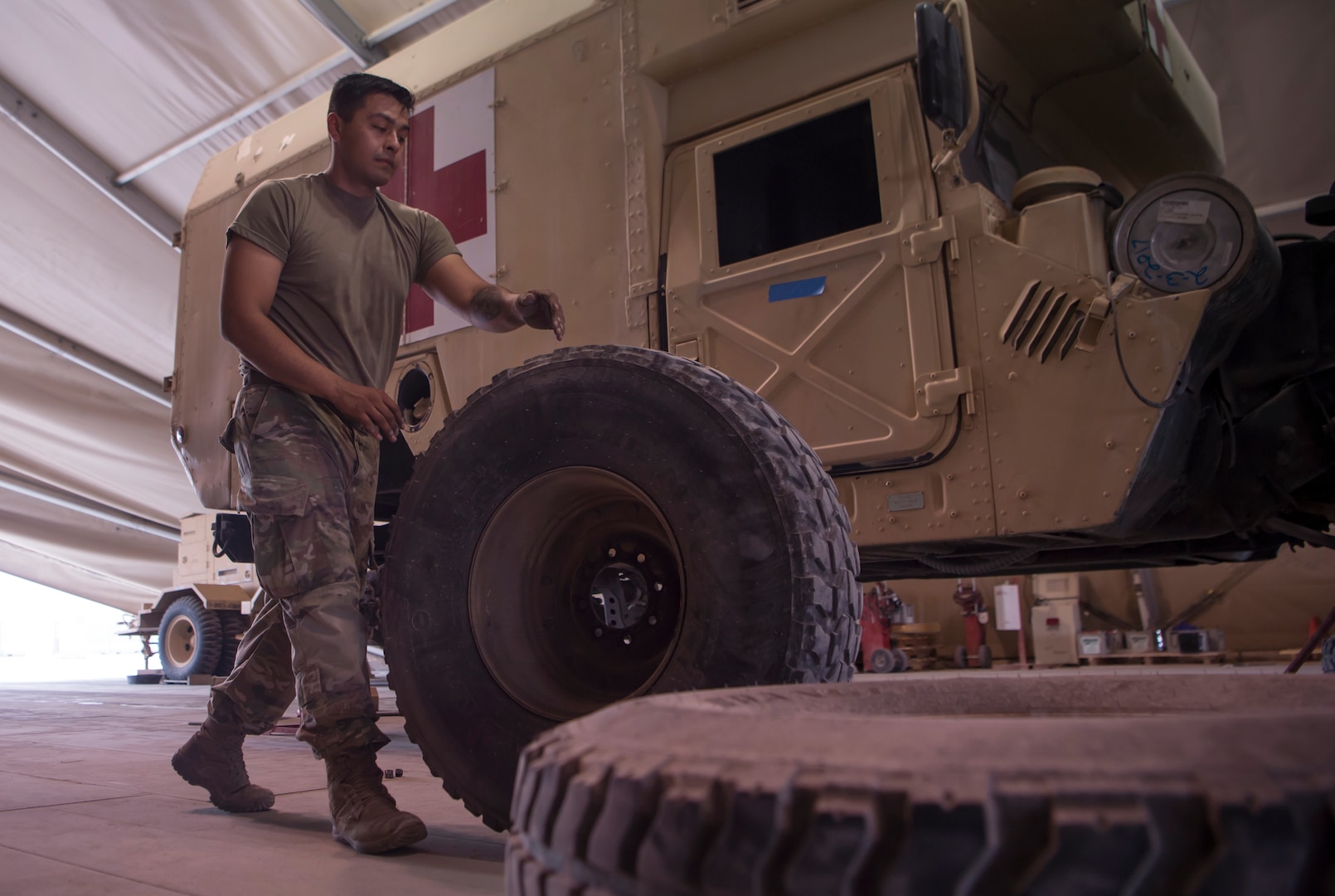 U.S. Army Spc. Abraham Garcia, Echo Company, 1st Battalion, 43rd Air Defense Artillery (ADA) Battalion, 11th ADA Brigade wheeled vehicle mechanic, moves a military vehicle wheel as part of a routine tire rotation Jan. 28, 2019, at Al Udeid Air Base, Qatar. Soldiers of Echo Company perform mechanical work and repairs for various equipment and assets that support Al Udeid’s air defense capabilities, including surface-to-air missile systems. (U.S. Air Force photo by Tech. Sgt. Christopher Hubenthal)