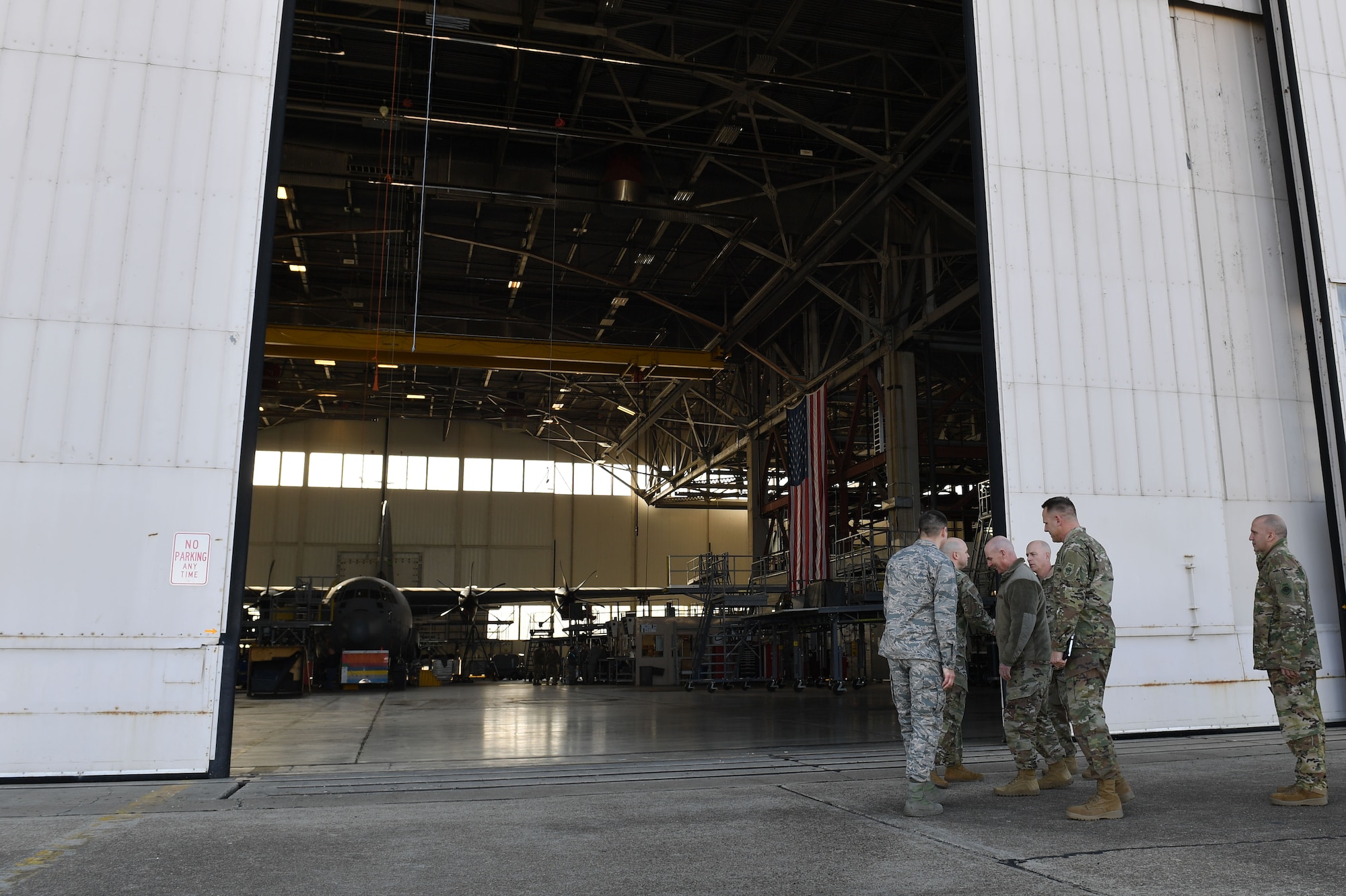 Men walk into a hangar.