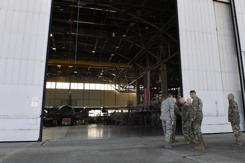 Men walk into a hangar.