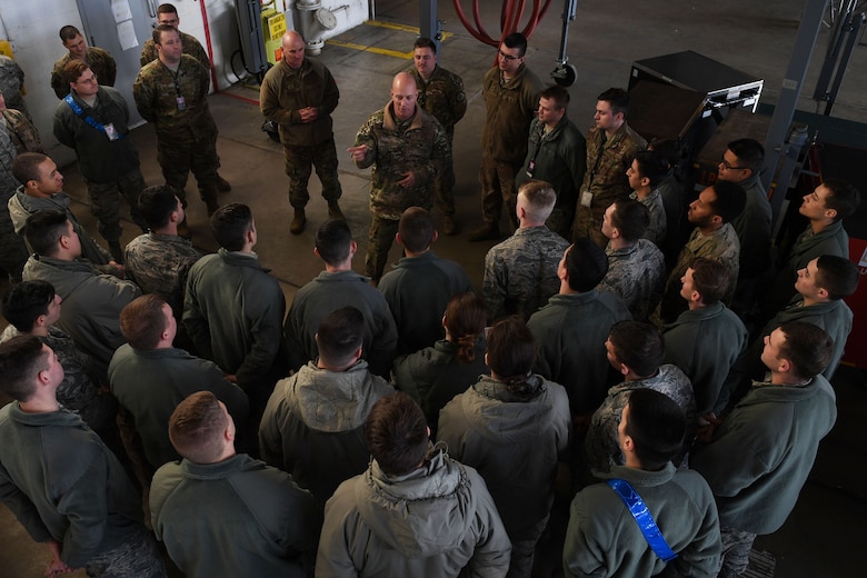 Airmen stand around a man.